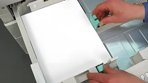 User adjusting printer paper guides